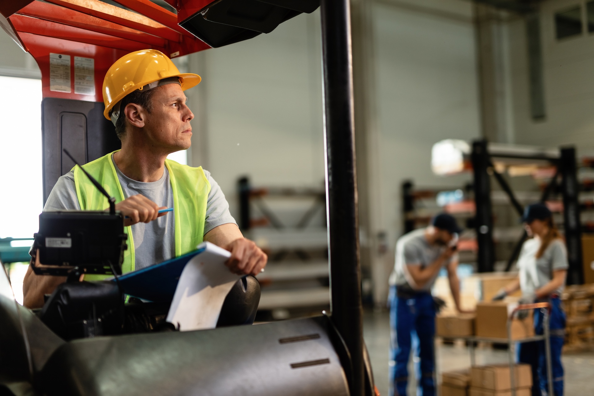 Pensive forklift operator working in industrial warehouse.
